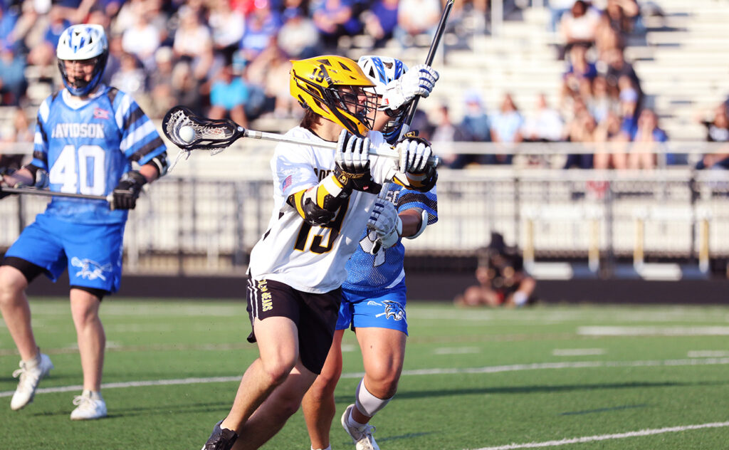 Upper Arlington's Jack Caine passes lacrosse ball