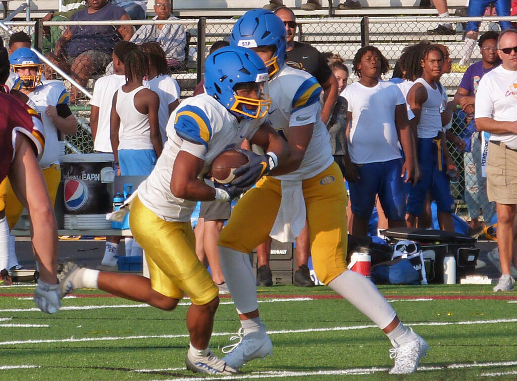 Gahanna Lincoln's Biore Hubbard hands football to Brennen Ward