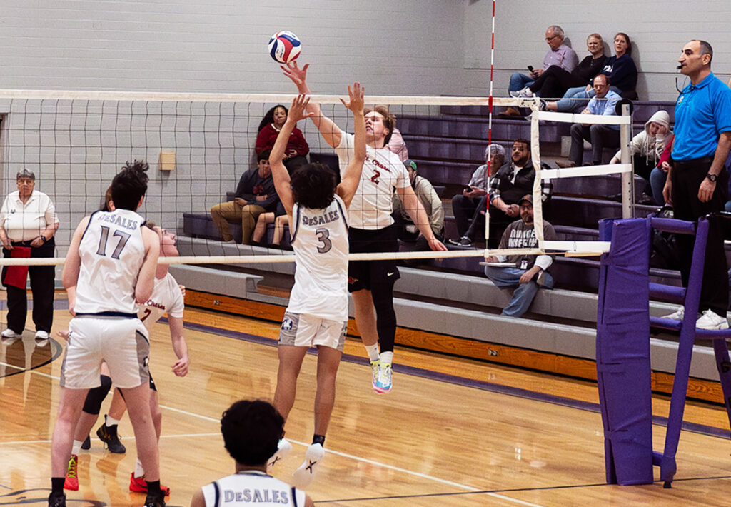 St. Charles' Jack Koesters hits volleyball at net