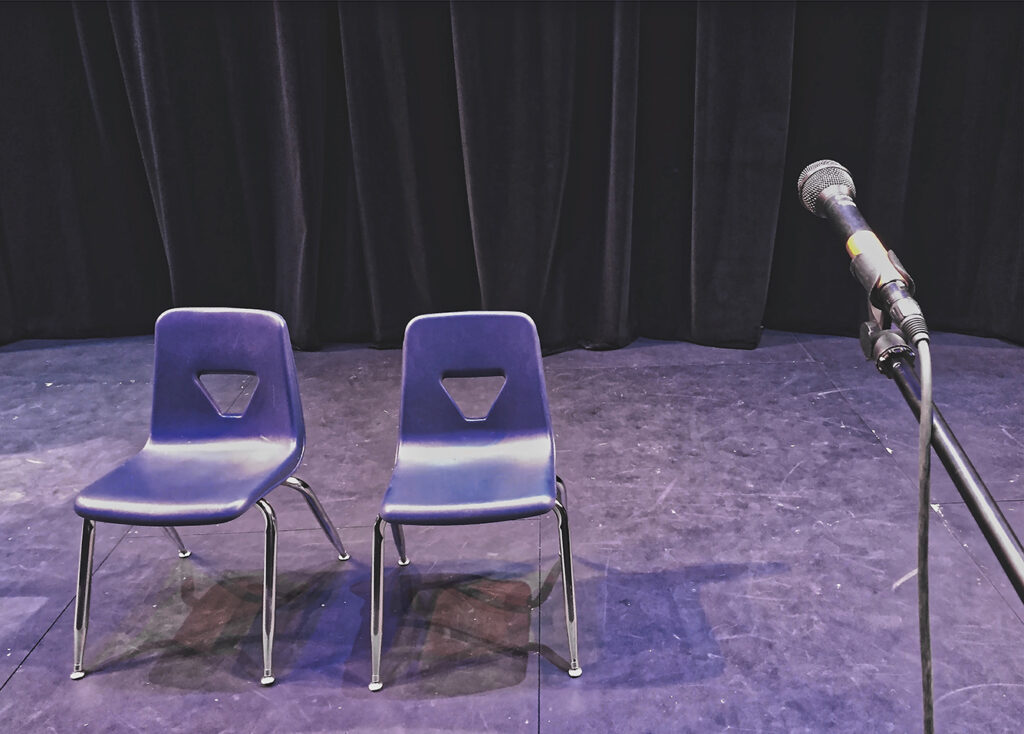 Empty chairs on stage with microphone