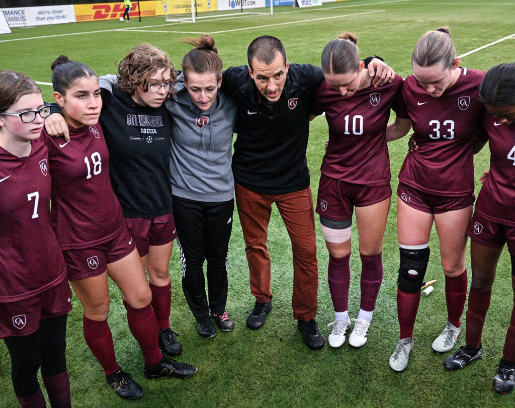 Academy huddles before the game