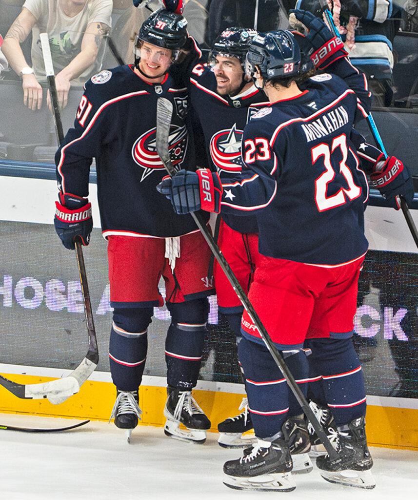 CBJ Conor Garland celebrates with team side graphic