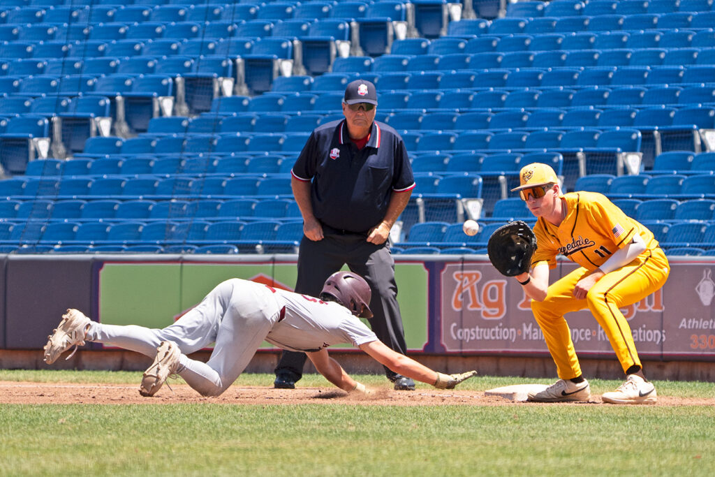 Academy's Dominic Dunkle dives into first base