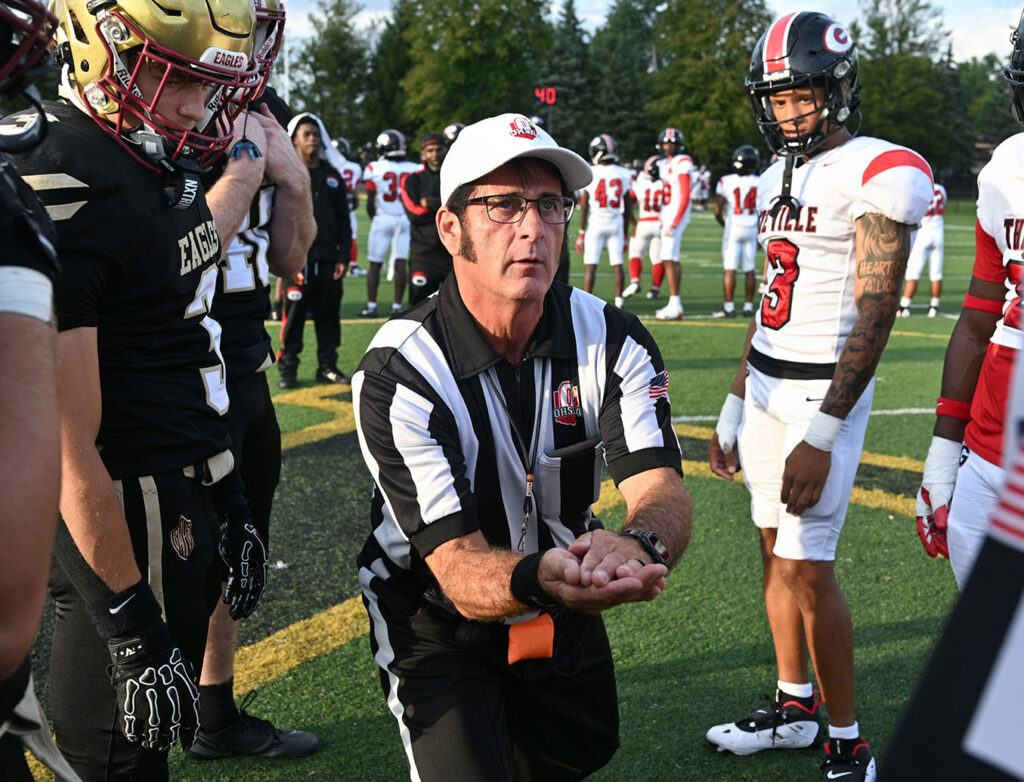 Referee holds coins before Watterson football game
